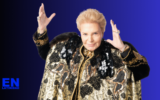 Walter Mercado dressed in a flowing gold and red cape, smiling warmly during a television appearance, symbolizing his iconic presence and lasting influence on Latino spirituality and pop culture.
