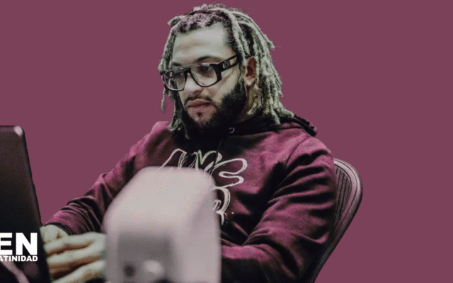 Dominican music producer Xtassys in the studio, wearing headphones and focused on mixing tracks, capturing the creative energy behind reggaeton hits.